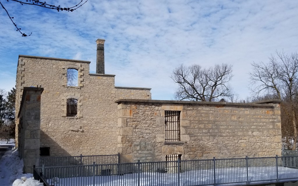 Stone wall ruins of Goldie Mill, a flour mill built in 1866, pictured in Guelph Ontario on a bright snowy day.
